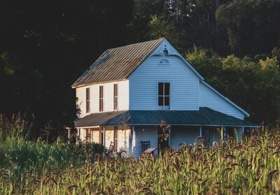 white farmhouse in a field of grass