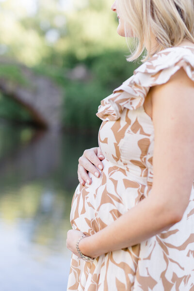 closeup of woman holding pregnant belly by NYC maternity photographer