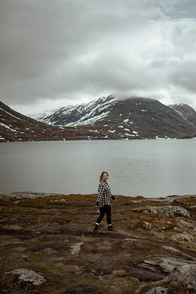 Fotograf Olivia Kylefjord står bland snöiga fjordar