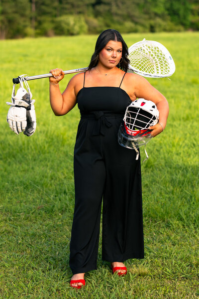 a lacrosse player stands in a field during a senior photo session in rome, georgia