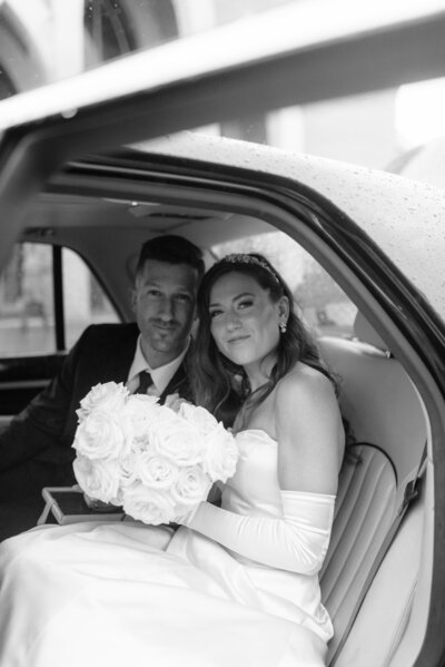 bride and groom wedding photo in back of limo with wedding bouquet and wedding dress at wedding in westminster maryland