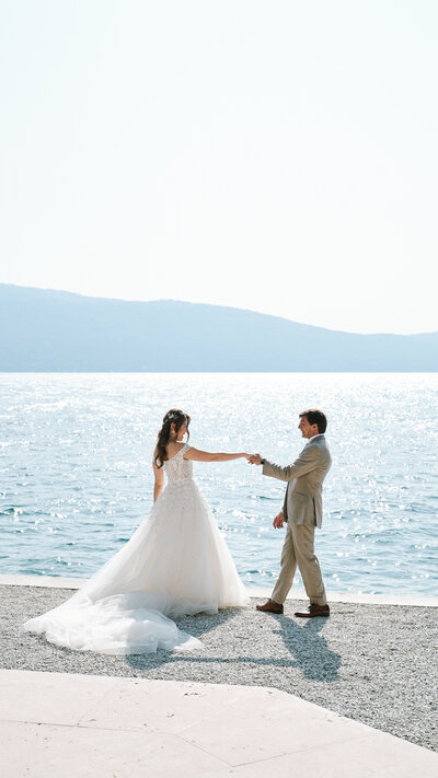 bride and groom dancing by the lake