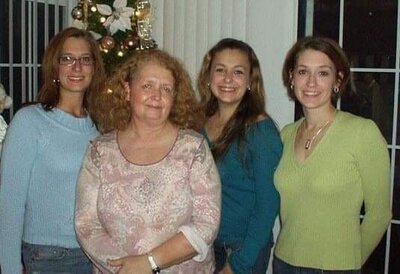 Kara Michelle’s mother and sisters posing together in front of a Christmas tree.