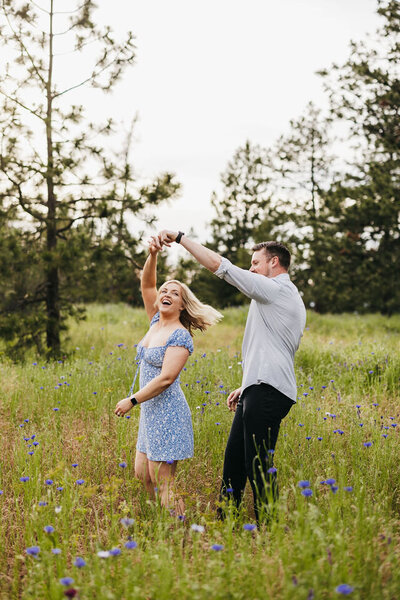 Couple laughing in a field of blue wildflowers
