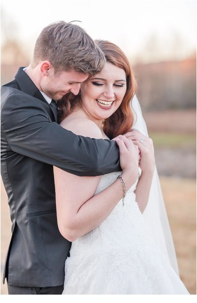 bride and groom smiling and hugging each other during their heritage acres clarksville arkansas wedding