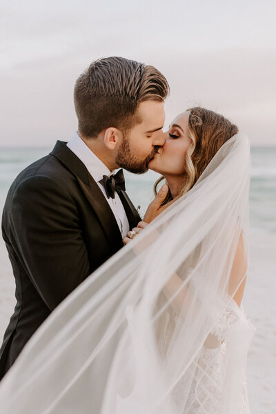 newlyweds kiss behind veil