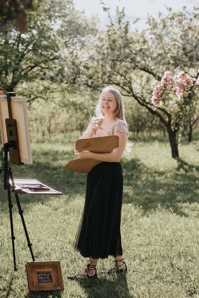 artist with easel in scenic blossoms
