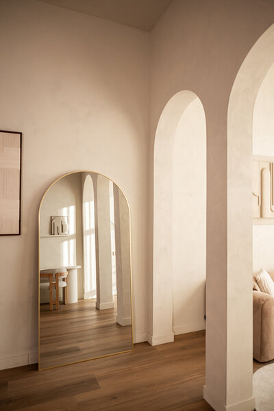 Luxe en comfortable fautueil met olijfboom en een organisch gevormde spiegel