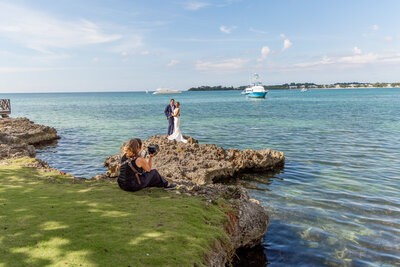 photographer taking photo of couple near ocean
