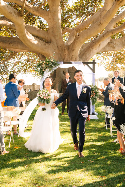 A newlywed couple holds hands after their wedding ceremony in San Pedro, Ca.