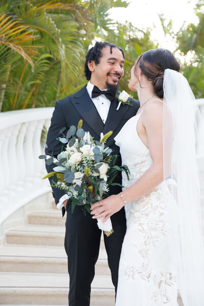 An Austin-based wedding photographer captures the bride and groom standing on the steps of a resort.