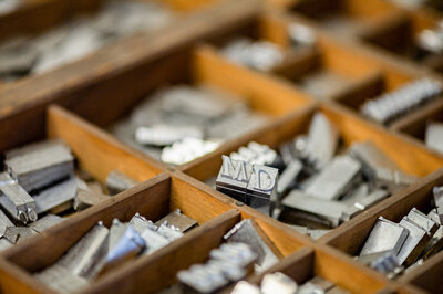 Flat lay branding image of letterpress alphabet in a wooden box.