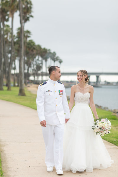Bride and Groom walking down a pathway at their wedding venue at The Dana in San Diego