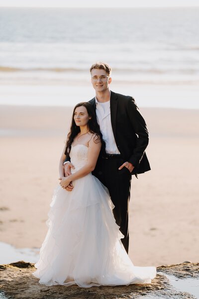 wedding couple taking a photo on the beach