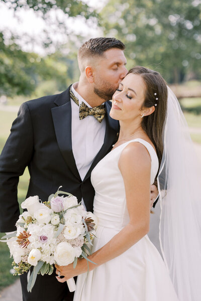 Groom kisses bride at ceremony at valley brook country club