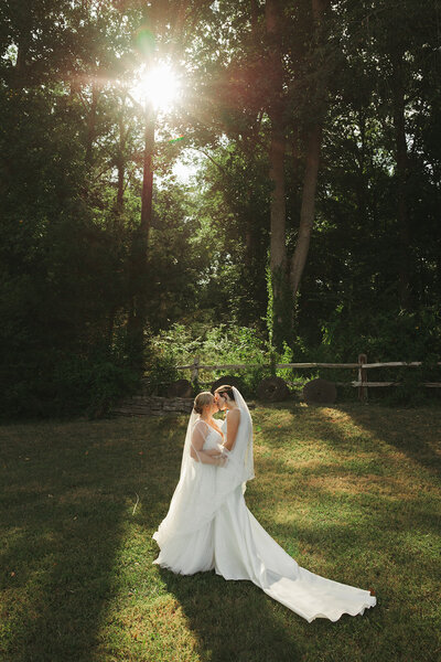 two brides wearing wedding dresses kiss
