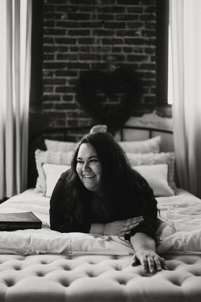 Woman laying on a bed during a boudoir session in Portland, Oregon.