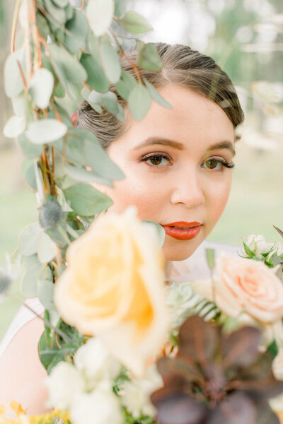 bridal portrait of bride with flowers sitting on a swing