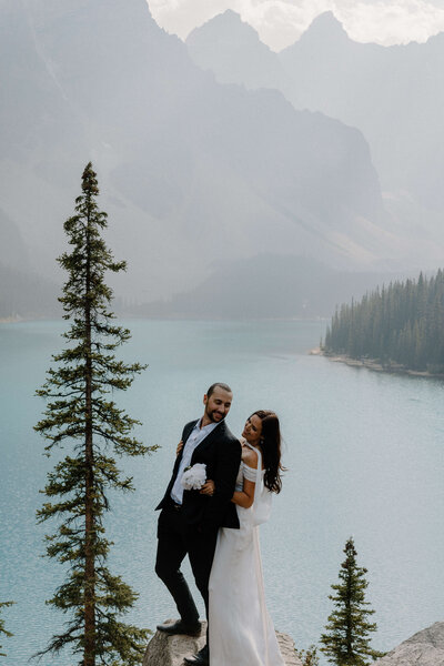 Bride and groom standing in front of mountains