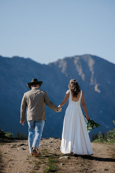 Wedding and Elopement Photography, Bride and groom walk on trail at Colorado mountain elopement.