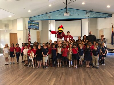 Students poseing for photo with Big Red from Arizona Cardinals