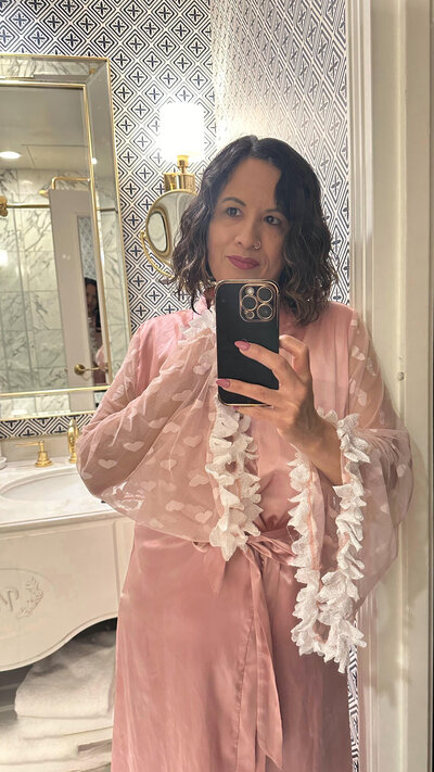 woman in a pink robe in fancy hotel bathroom