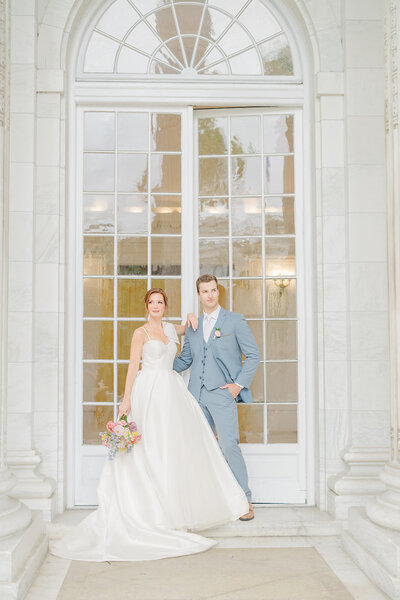 Elegant wedding portrait captured at the DAR (Daughters of the American Revolution) in Washington DC, featuring a bride in a stunning gown and a groom in a light blue suit. Felisha, a New England-based destination wedding photographer, specializes in weddings across Boston, Rhode Island, New England, and worldwide, preserving timeless moments of love and connection.