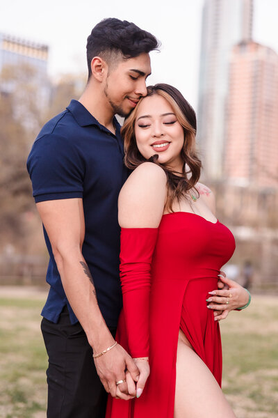 Couple embrace during their engagement session at Butler Park in Austin, Texas. Photo taken by Austin Engagement Photographers, Joanna & Brett Photography