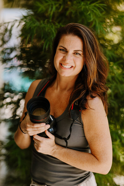 Jaime Bugbee, vanco photographer, holding her camera and smiling