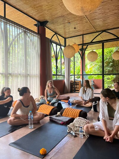 A group of women talking after a yoga session in a yoga studio