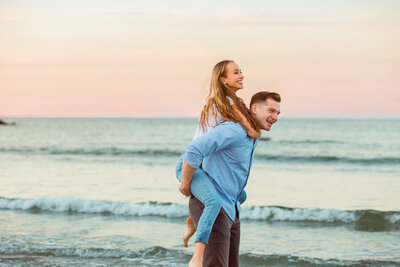 An engaged couple laugh on Wingaersheek Beach.