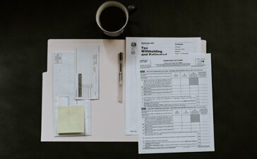 Tax forms next to coffee  to symbolize freelance taxes