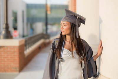 Girl staring off into the golden sunset light during college graduation milestone photo session in Charlotte NC
