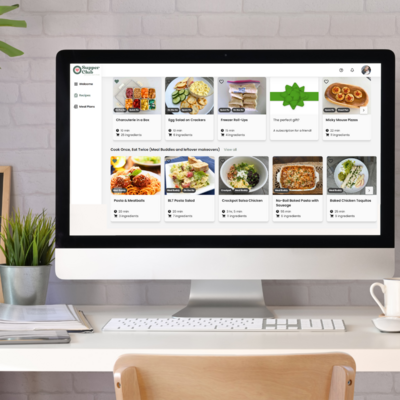 Desktop computer displaying the Supper Club app recipe library with meal options like pasta, chicken dishes, and freezer roll-ups.