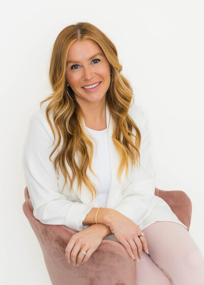 woman leaning against desk smiling