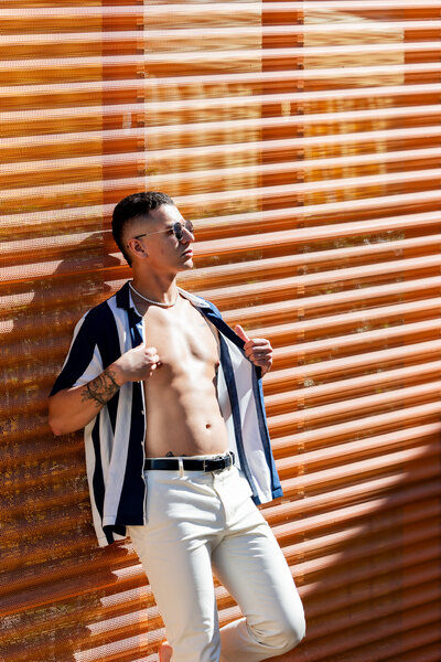 Radiating confidence under the Palm Springs sun, this bold fashion moment exudes modern charm. The crisp white pants, open striped shirt, and effortless pose capture a timeless yet contemporary vibe.