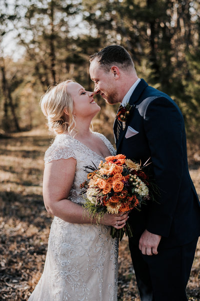 A bride and groom give eskimo kisses