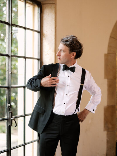 November wedding at Graylyn Estate, designed and planned by Charming Carolina — groom putting on his jacket inside the historic manor house before the ceremony.