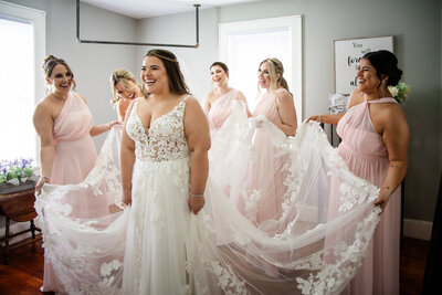 bridesmaids fluffing and helping the bride getting ready by NH Wedding Photographer  lisa smith photography