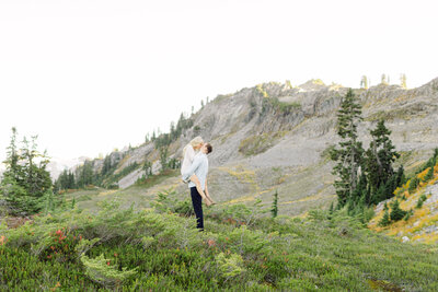 a man and woman in the mountains embracing and kissing