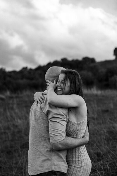 Couple hugging and laughing just after a proposal during their Albury engagement photo shoot with Heartfully Captured.