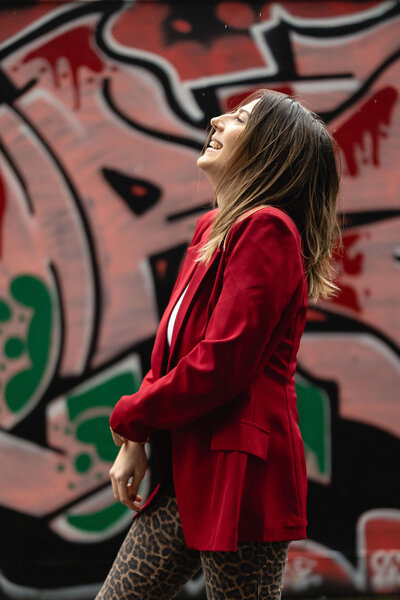 Emma, an Ireland wedding planner, smiling with graffiti as the backdrop