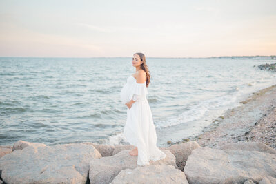 A cozy lifestyle newborn session in the client’s home featuring a swaddled newborn resting peacefully on a bed. Beside the baby, the family dog sits sweetly, watching over its newest family member, creating a heartwarming moment of love and companionship