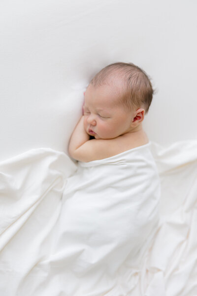 newborn swaddled in white