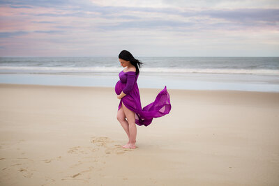 pregnant woman in purple on the beach by philadelphia maternity photographer