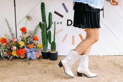 Austin corporate event styling featuring desert-inspired florals, potted cactus, and branded event signage.