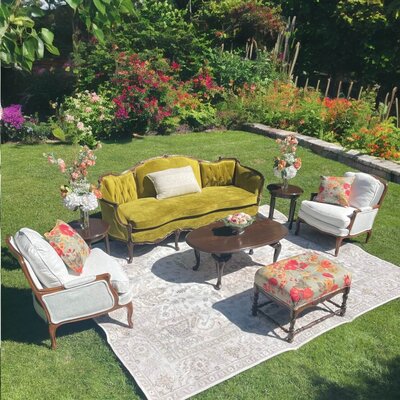 Arrangement of furniture in a garden. Representing Flutter Event Rentals vendor profile for the Crush Collective wedding show.