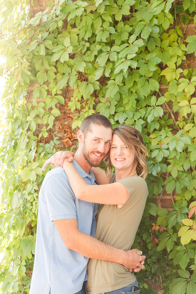 Engaged couple holding hands and laughing in black and white