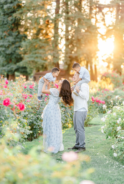 Family of three stands and playfully interacts playfully in a flower field, photography from Bay area photographer Light Livin Photography