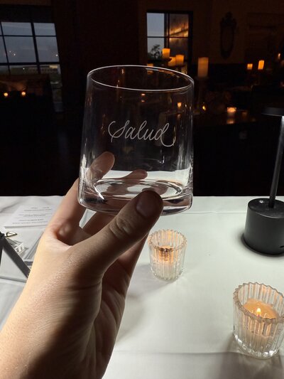 A glass with Salud hand-engraved onto it at a Scottsdale corporate event by a live engraver